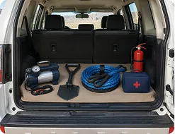 Tyre compressor, recovery shovel and tow rope in the boot of a Pajero
